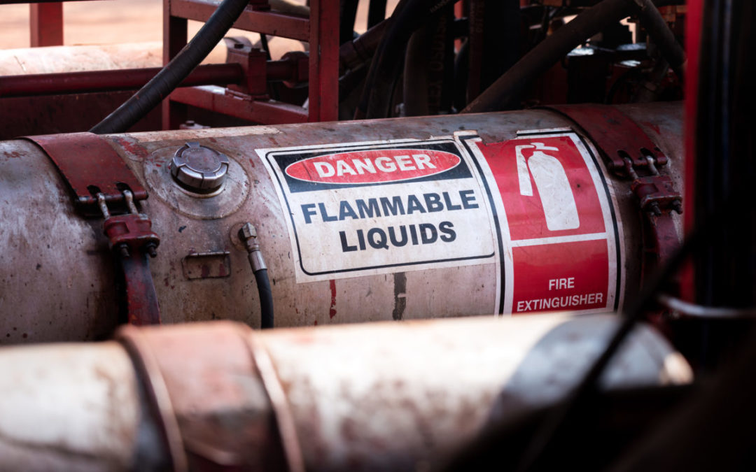 Flammable liquid (such as oil, fuel or hydraulic) container with standard caution sign on the body part. It's using in heavy industry and oil field operation.